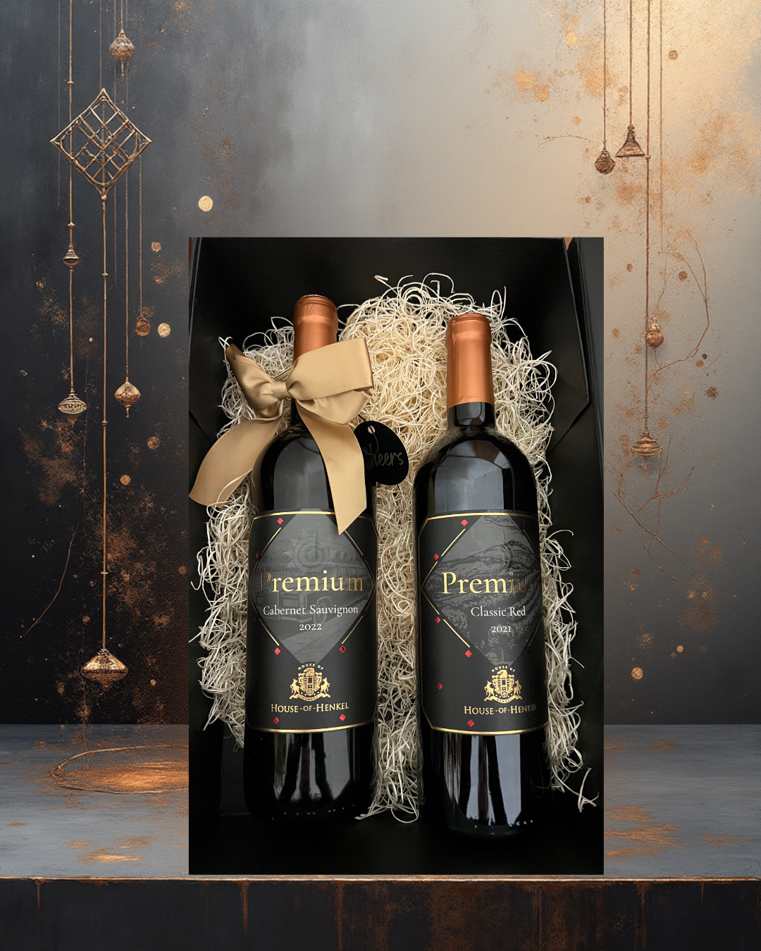 Two bottles of House of Henkel premium collection wine in a decorative box with a gold bow on a dark background.